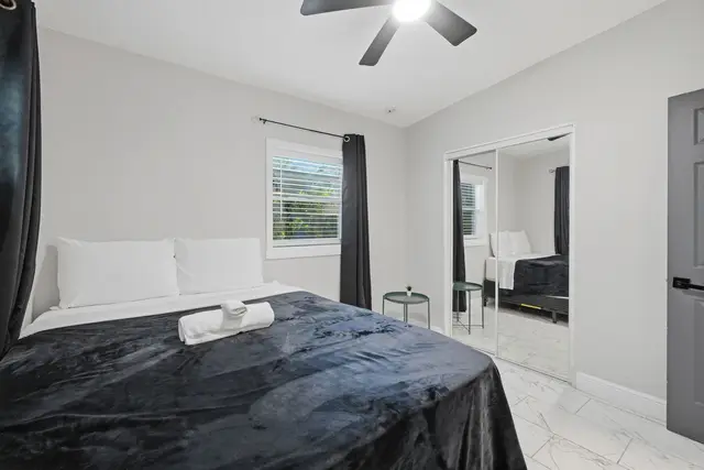 Modern, cozy bedroom with mirrored closet and bright natural light at Game Day Getaway-Downtown Orlando