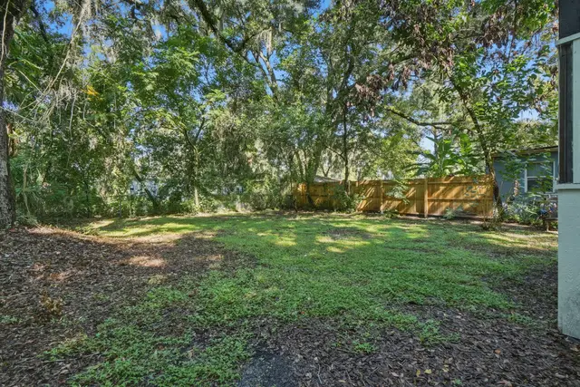 Spacious fenced backyard with mature trees and peaceful shade at Game Day Getaway-Downtown Orlando