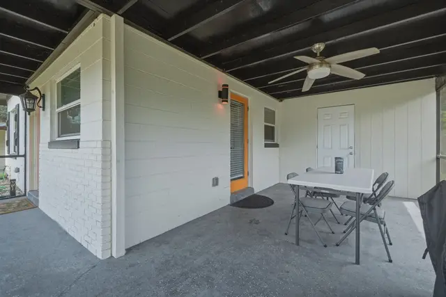 Covered patio with ceiling fan and outdoor dining space at WinterPark Home