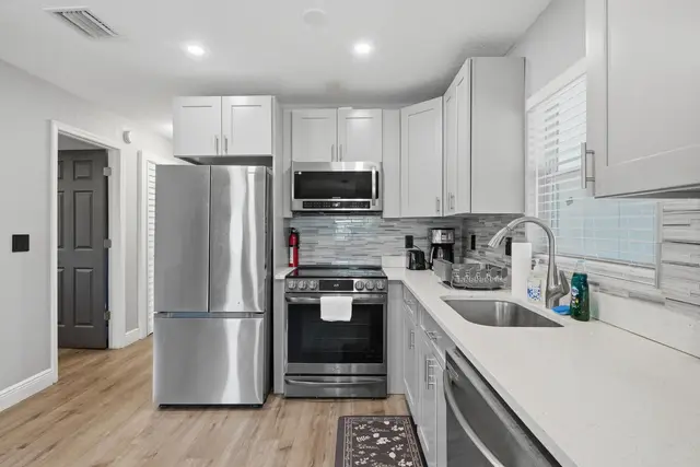 Modern galley kitchen with stainless appliances and bright finishes at WinterPark Home