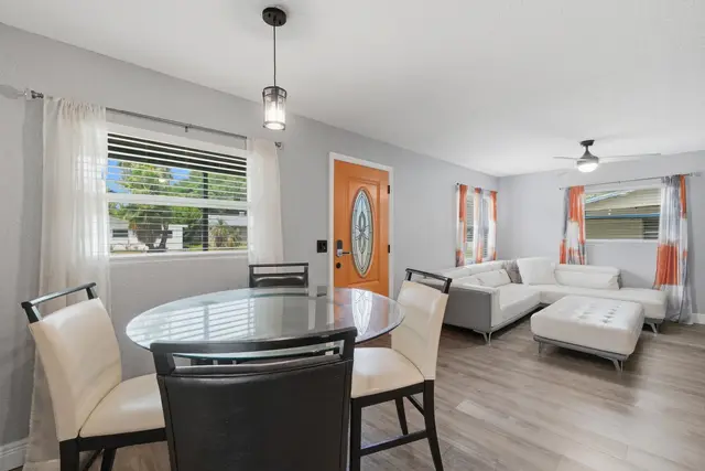 Bright modern living space with glass dining table and cozy sectional at WinterPark Home