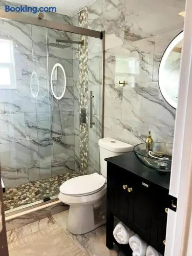 Spa-style bathroom with glass shower and elegant marble-look finishes at WinterPark Home