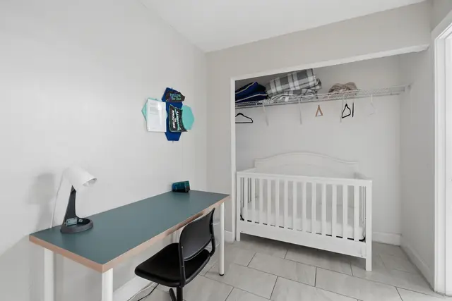 Family-friendly room with crib and compact workspace at The Clue House