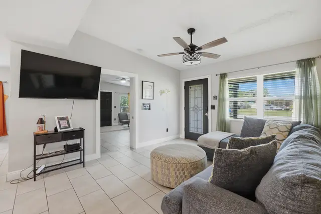 Bright, cozy living room with large sectional, smart TV, and natural light at The Clue House