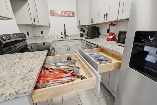 Modern stocked kitchen with granite counters and stainless appliances at The Clue House