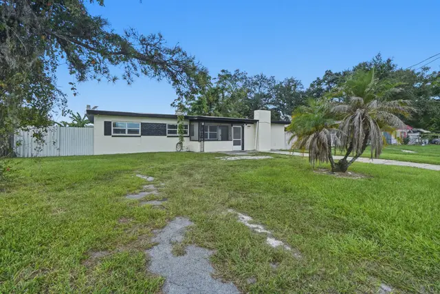 Spacious single-story home with large yard and tropical curb appeal at The Clue House