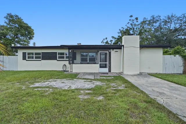Charming single-story home with fenced yard, driveway, and curb appeal at The Clue House