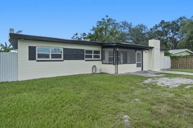 Spacious fenced backyard with screened patio for easy outdoor living at The Clue House