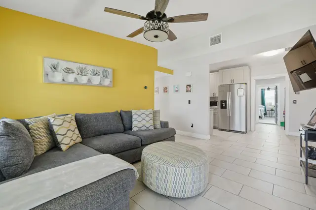 Bright open living room with comfy sectional and modern kitchen at The Clue House