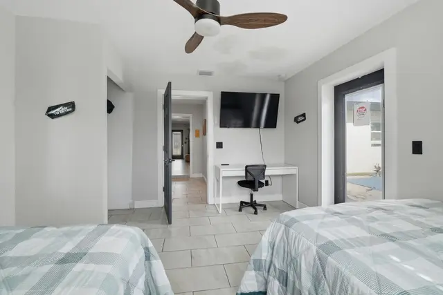 Bright double bedroom with TV, workspace, and private outdoor access at The Clue House