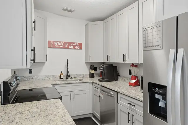Bright modern kitchen with stainless appliances and ample counter space at The Clue House