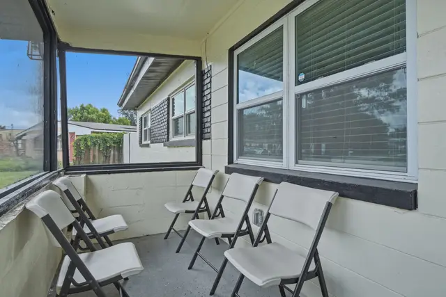 Screened-in porch with seating for relaxing outdoor moments at The Clue House