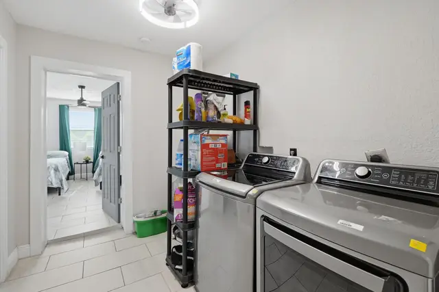 Convenient in-home laundry with stocked shelves and modern appliances at The Clue House