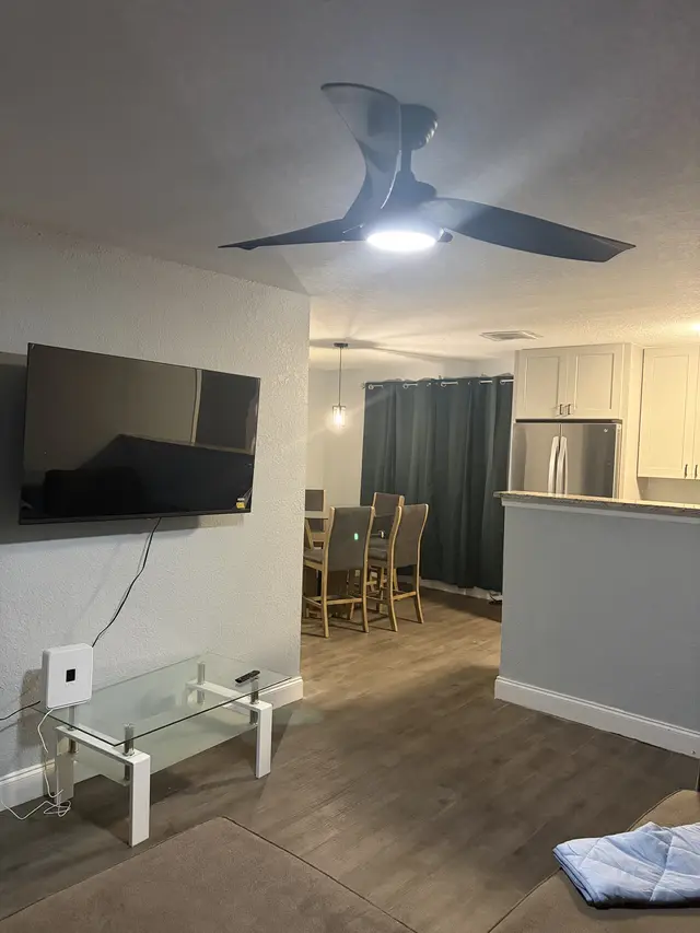 Open-plan living with TV, dining for six, and modern kitchen. at Downtown & Stadium Cozy Retreat