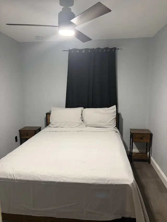 Cozy queen room with blackout curtains, ceiling fan, and modern style at Downtown & Stadium Cozy Retreat