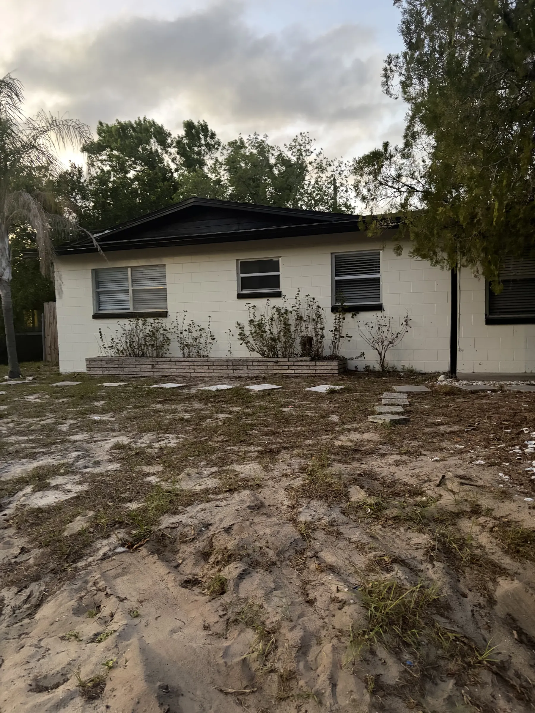 Single-story retreat with shady yard, stepping stones, and planters at Downtown & Stadium Cozy Retreat