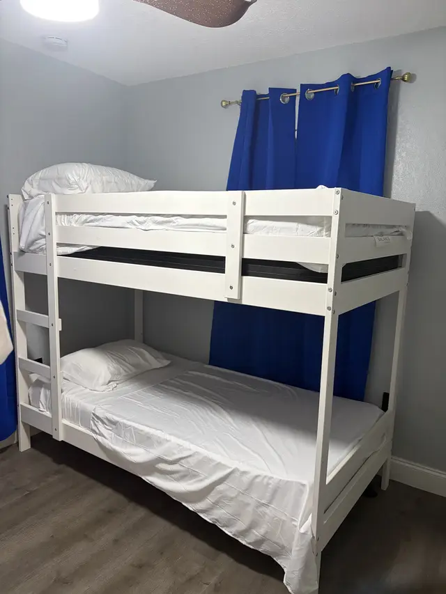 Cozy bunk room with twin-over-twin beds, blackout drapes, sleek floors. at Downtown & Stadium Cozy Retreat