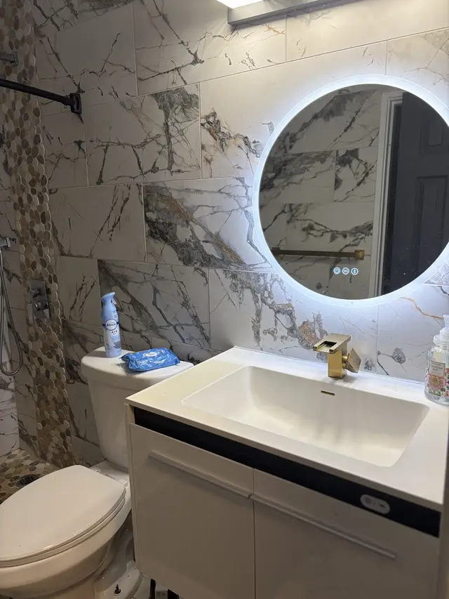Modern bath with LED mirror, marble tile & pebble shower at Downtown & Stadium Cozy Retreat