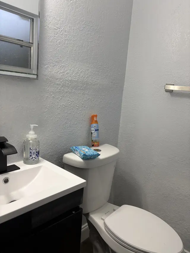 Clean, compact bath with modern vanity, frosted window, and essentials. at Downtown & Stadium Cozy Retreat